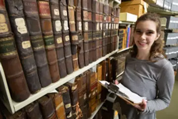 学生的照片,丽贝卡Denz旁边一堆图书馆的书