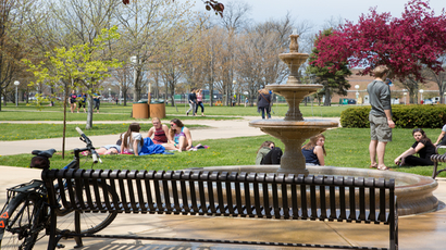 学生们坐在威廉姆斯中心外喷泉附近的草地上